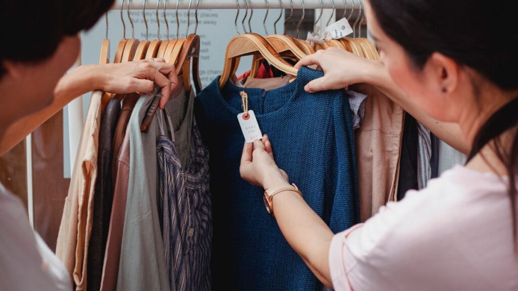 Dos mujeres eligiendo prendas de ropa en una tienda